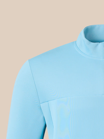 Close-up of a light blue long-sleeve top with a mock neck collar and a subtle tonal vertical texture, shown against a solid beige background.