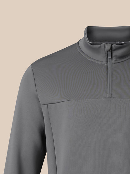 Close-up of a gray long-sleeve quarter-zip pullover with a mock neck collar, shown on a plain beige background.