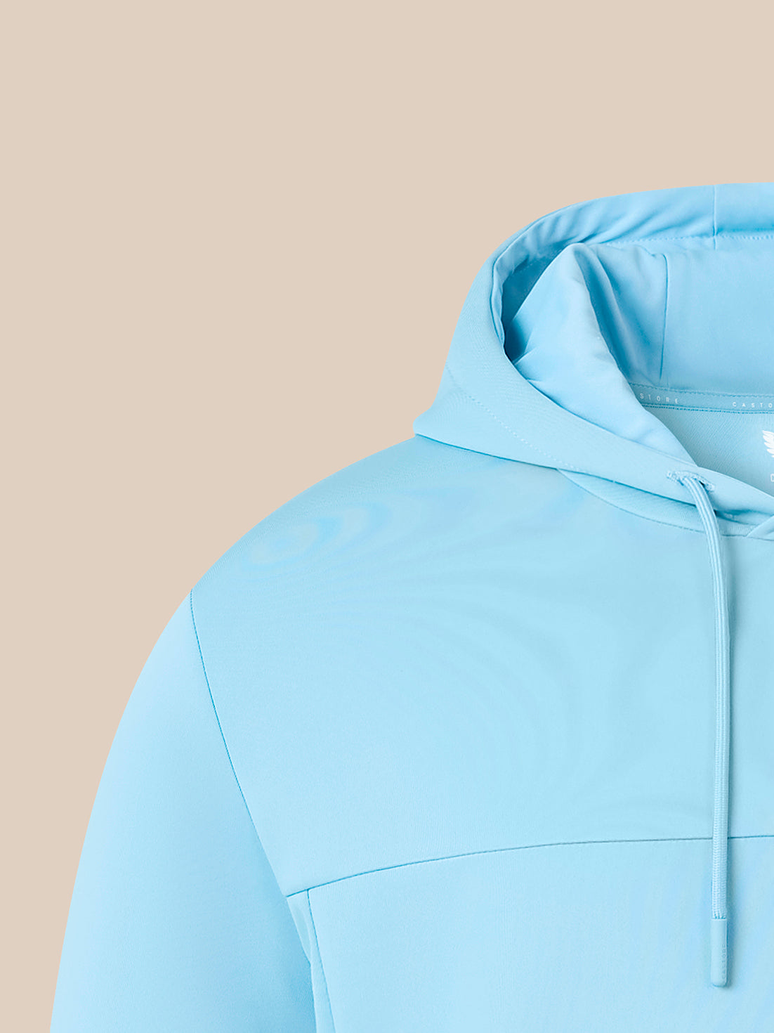 A close-up of a light blue hooded sweatshirt on a model, showing the hood, drawstrings, and shoulder area against a solid beige background.