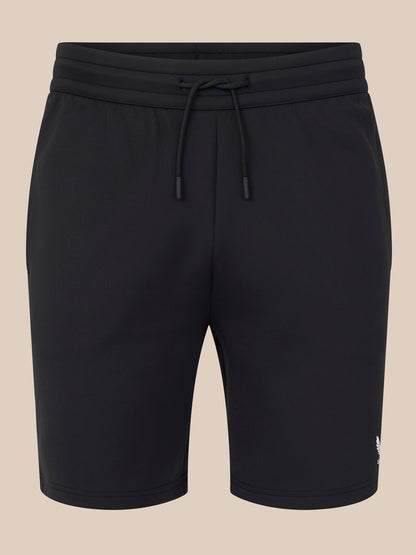Black shorts with a drawstring on a beige background
