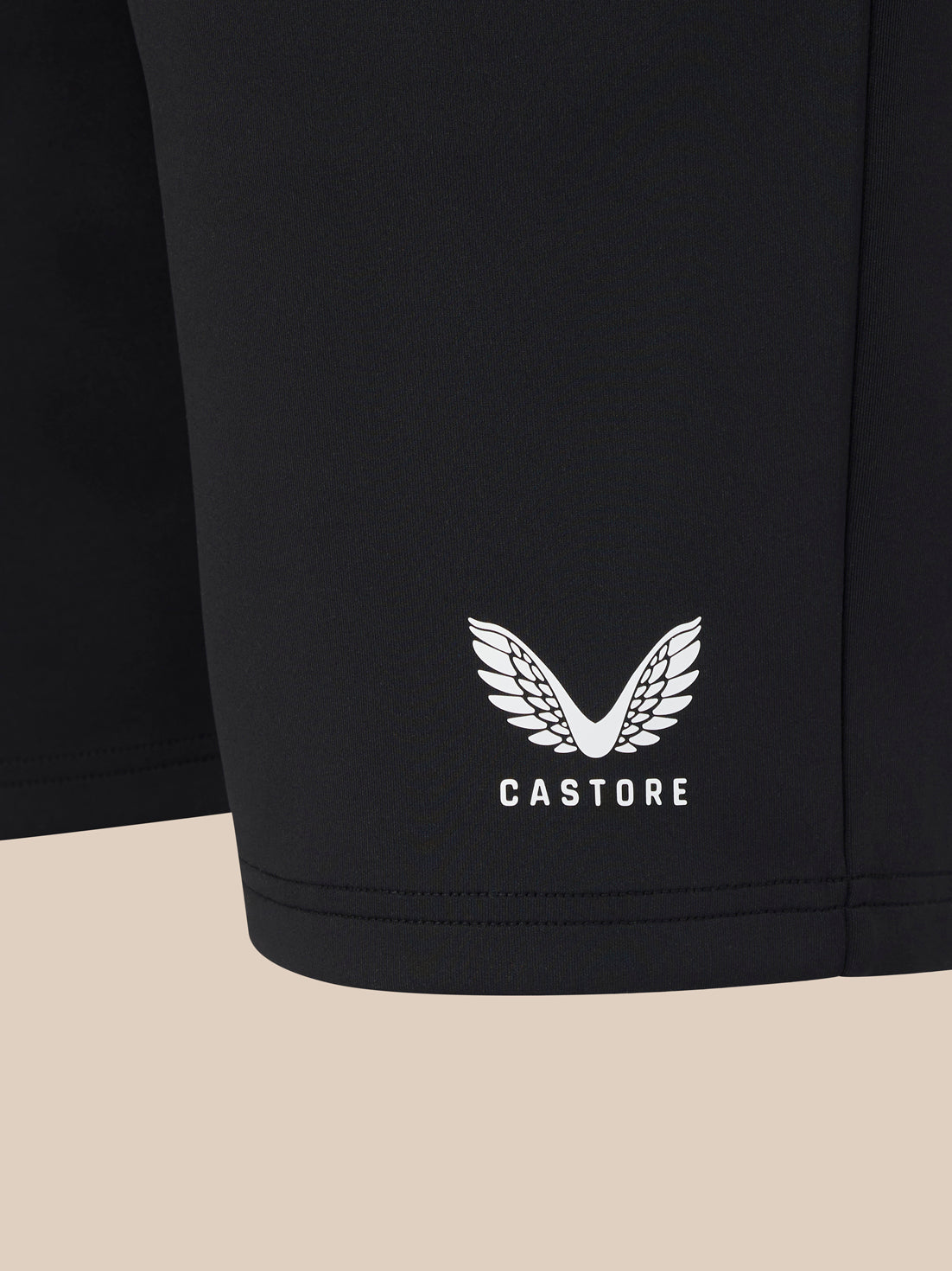 Black shorts with a white logo and text on a beige background