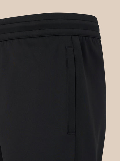 Close-up of black pants on a beige background