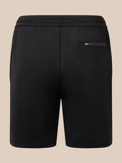 Black athletic shorts with an elastic waistband and a zippered side pocket, shown from the back on a solid beige background.