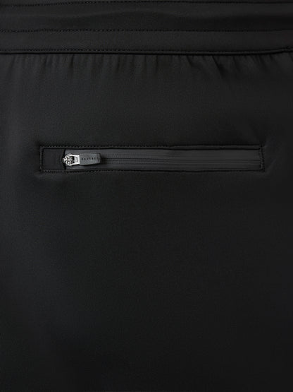 Close-up of a black garment featuring an elastic waistband and a horizontal zippered pocket with a small silver-tone metal pull tab.