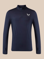 A navy blue long-sleeve quarter-zip athletic pullover with a white wing logo and the word 'Castore' on the left chest, displayed against a solid beige background.