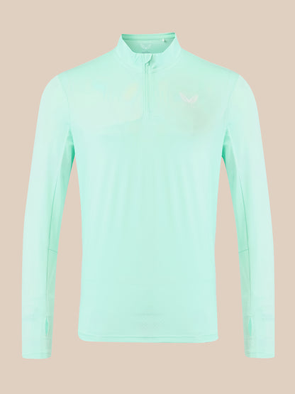A light mint green long-sleeve athletic quarter-zip pullover with a small white logo on the left chest, displayed on a solid beige background.