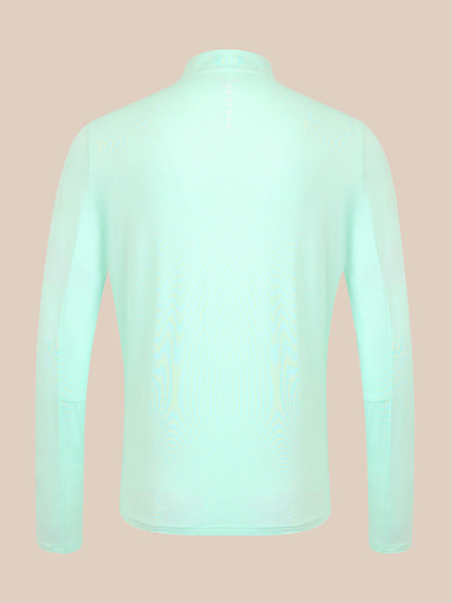 A long-sleeve high-neck top shown from the back, in a very pale mint green color, displayed on a solid beige background.