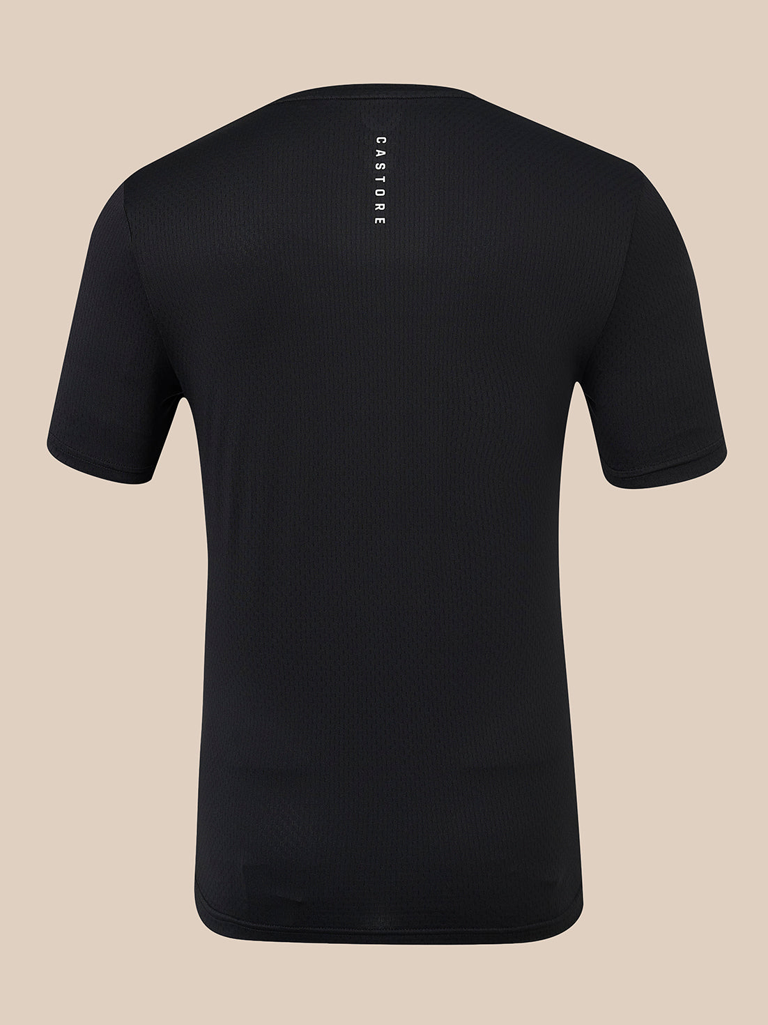 A black short-sleeve athletic t-shirt shown from the back, featuring a vertical white 'CASTORE' brand logo printed on the upper back, set against a solid beige background.