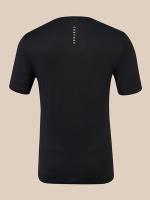 A black short-sleeve athletic t-shirt shown from the back, featuring a vertical white 'CASTORE' brand logo printed on the upper back, set against a solid beige background.