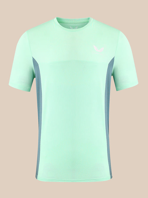 A mint green short-sleeve athletic t-shirt with gray side panels and a small white logo on the left chest, displayed against a solid beige background.