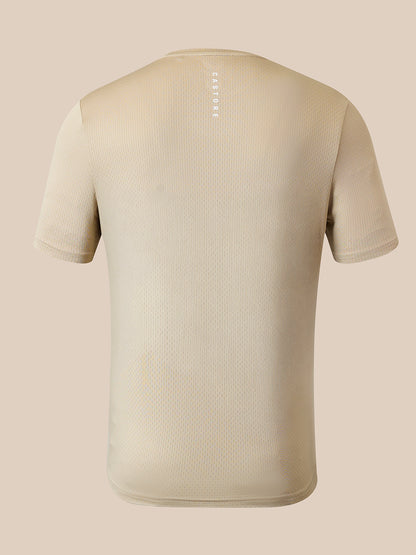 A beige short-sleeve athletic t-shirt shown from the back, featuring a subtle textured mesh pattern and a vertical white 'CASTORE' logo printed on the upper back, set against a solid beige background.