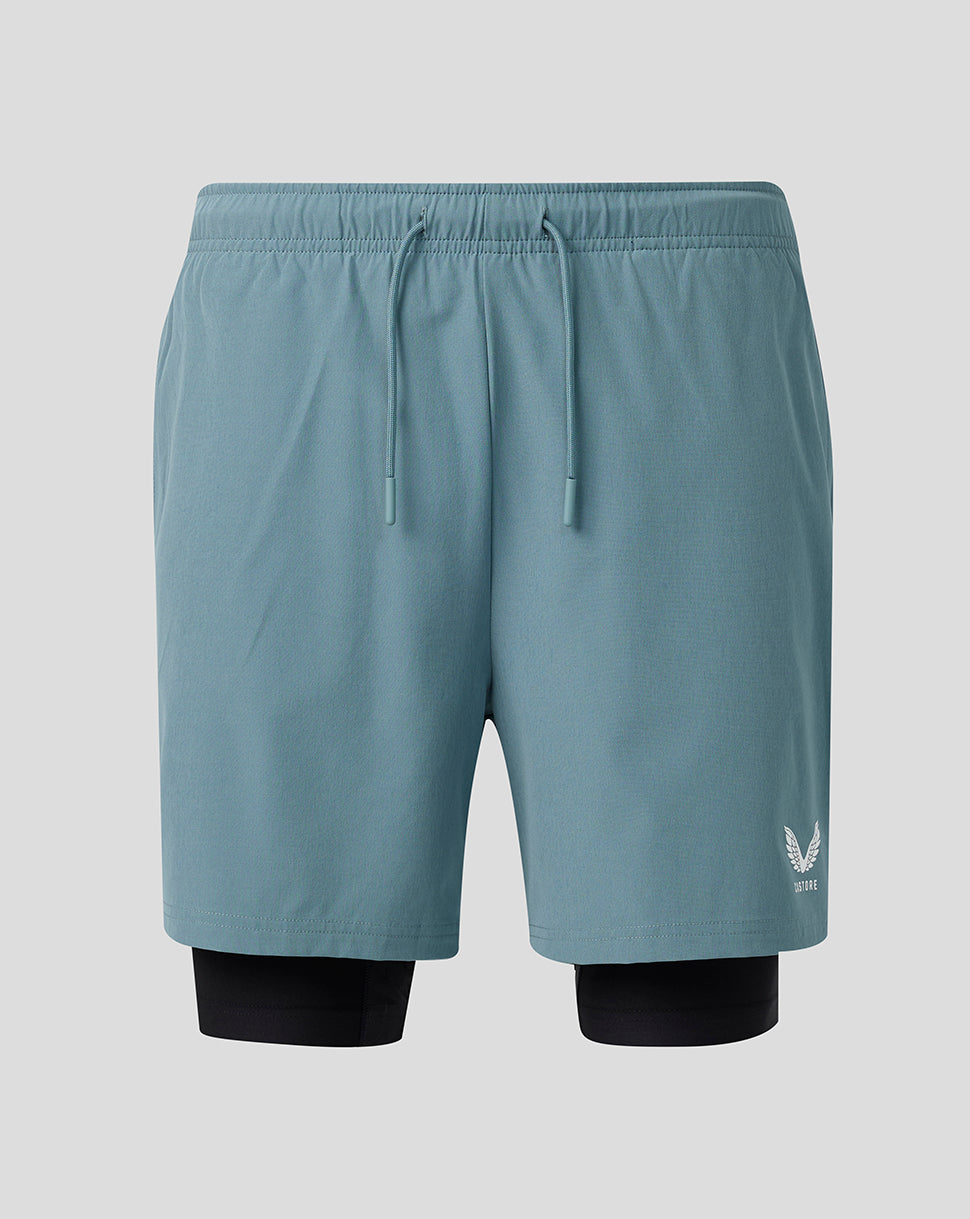 Light blue athletic shorts with a logo on a gray background