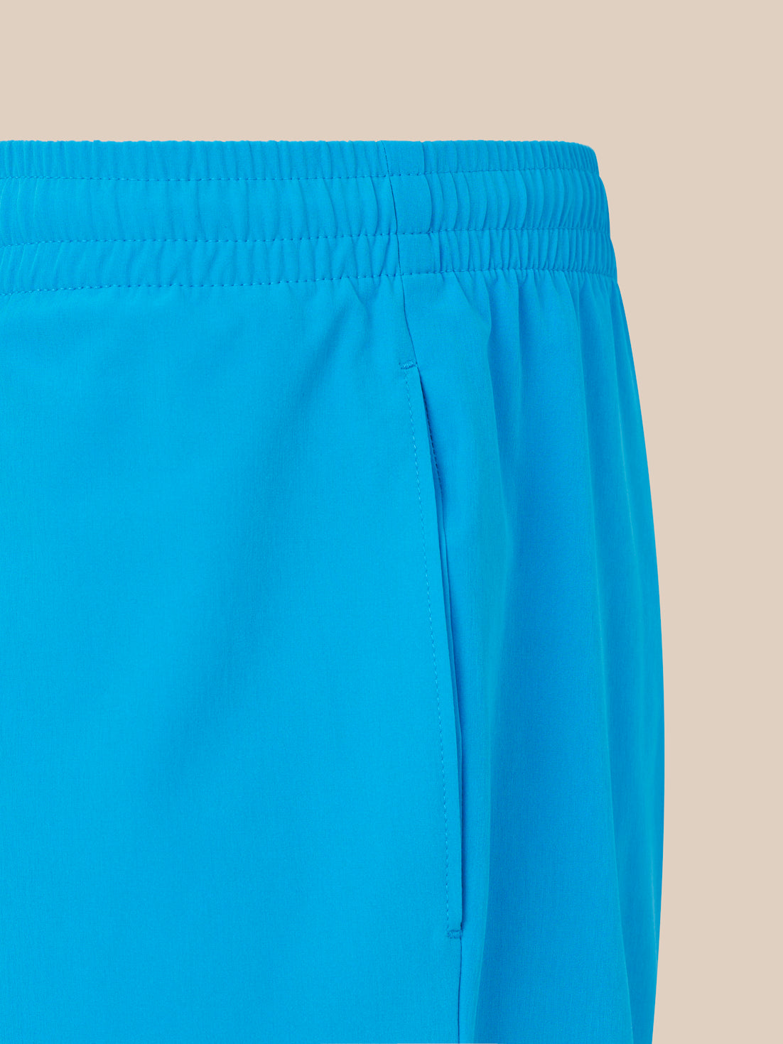 Close-up of blue shorts on a beige background