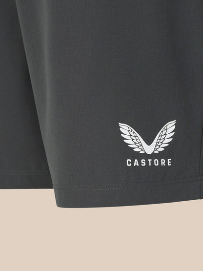 Dark gray shorts with a white logo and text on a beige background