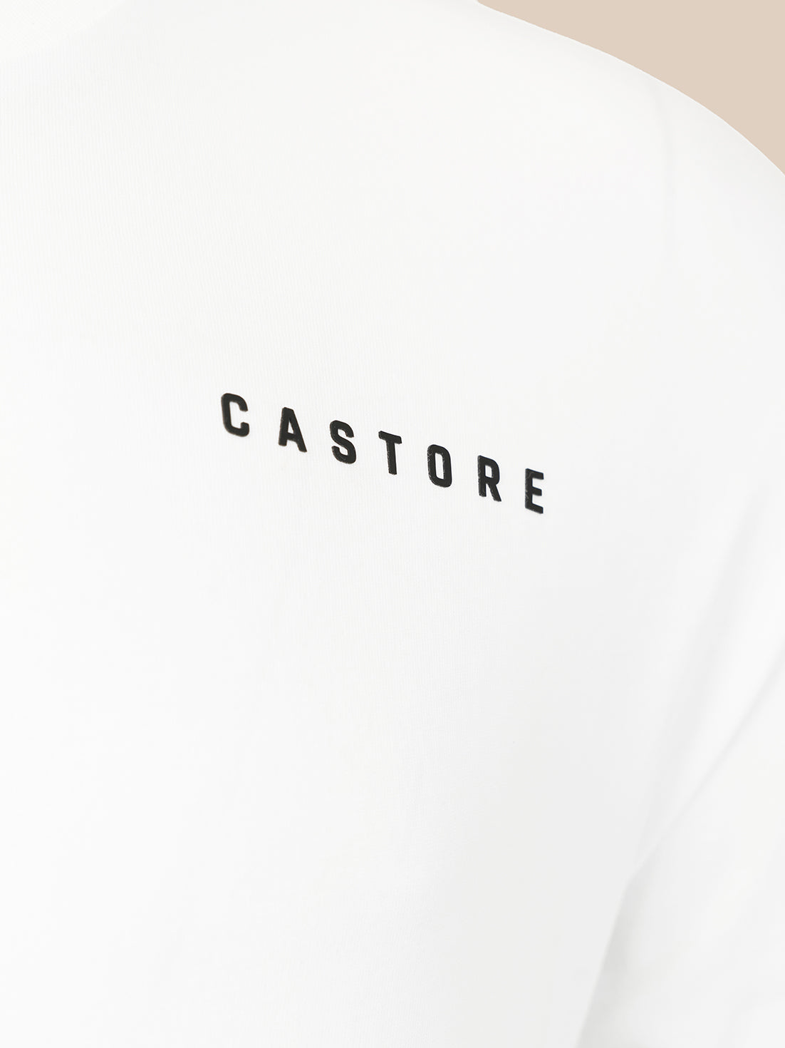 Close-up of a white garment with the word 'CASTORE' printed in black across the chest.