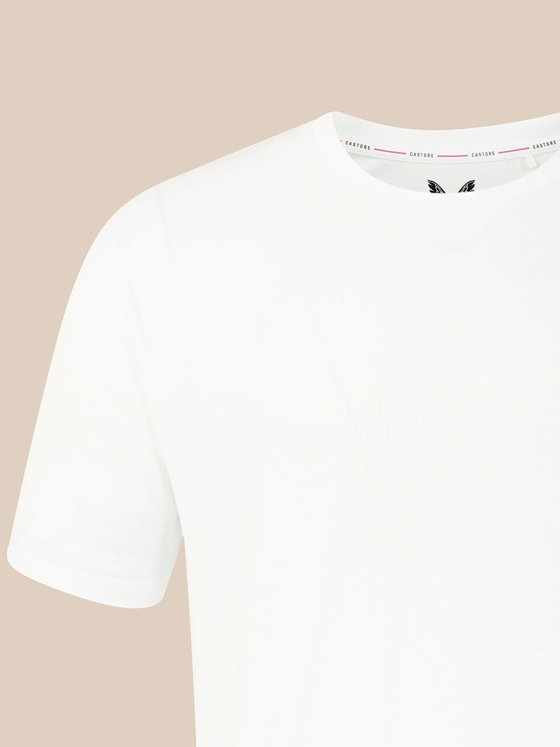 A close-up of a white short-sleeve crewneck t-shirt, showing the inner collar label with the brand name 'CASTORE' repeated, set against a solid beige background.