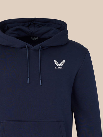 Navy hoodie with a logo on the chest against a beige background