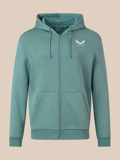 A teal green zip-up hoodie with a white winged logo on the left chest, displayed on a solid beige background.