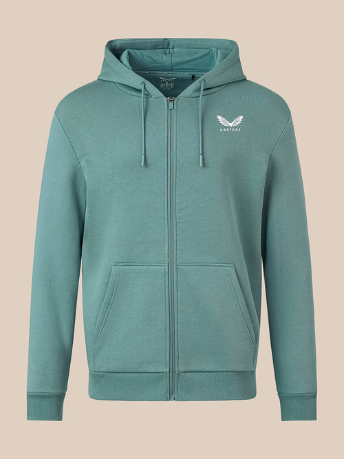 A teal green zip-up hoodie with a white winged logo on the left chest, displayed on a solid beige background.