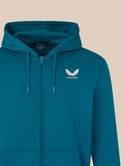 Blue hoodie with a logo on the chest against a beige background