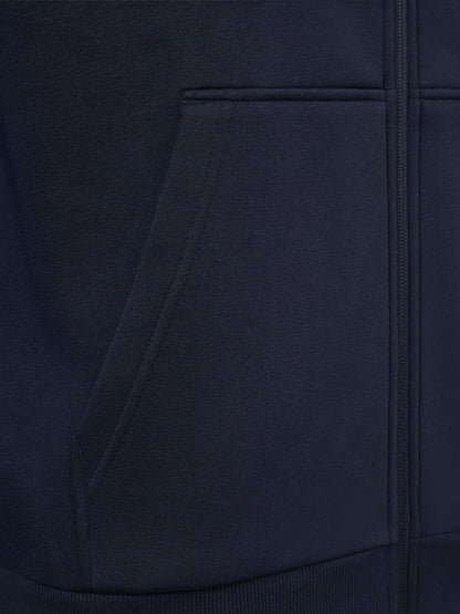 Close-up of a dark navy zip-up hoodie showing the fabric texture, a front pocket, and part of the zipper.