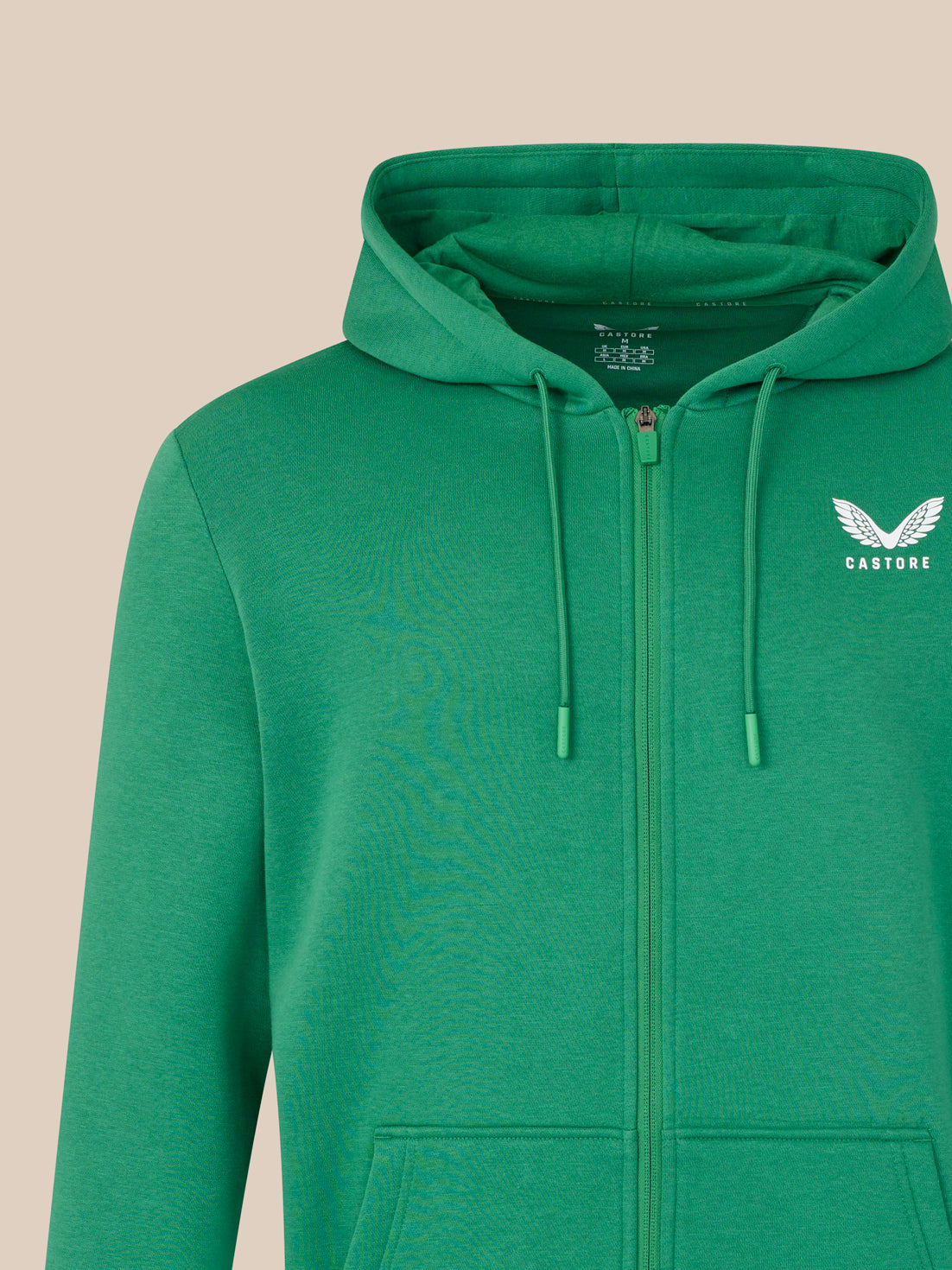 Green hoodie with a logo on a beige background