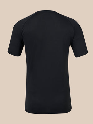 A black short-sleeve athletic t-shirt shown from the back, featuring raglan-style shoulder seams, displayed on a solid beige background.