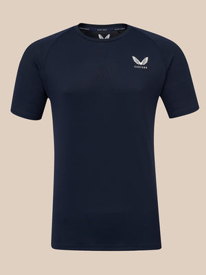 A dark navy blue short-sleeve athletic t-shirt with a white winged logo and the brand name 'CASTORE' printed on the left chest, displayed against a solid beige background.
