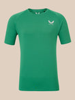 A green short-sleeve athletic t-shirt with a white winged logo on the left chest reading 'CASTORE', displayed against a solid beige background.