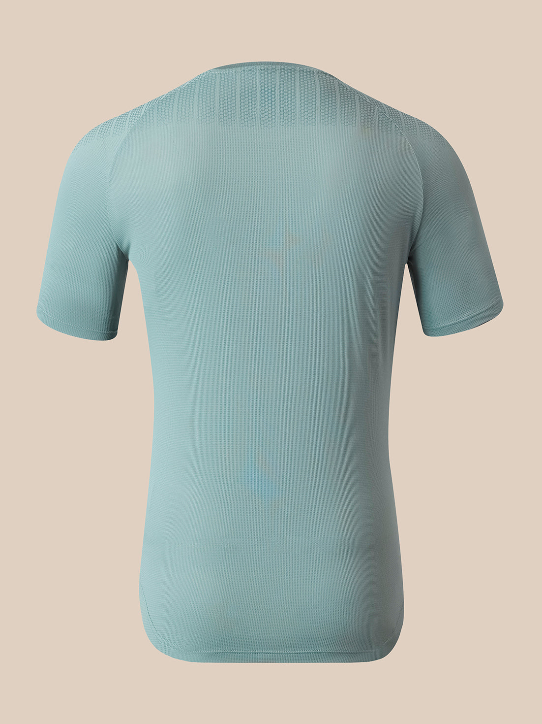 A light blue athletic t-shirt shown from the back, featuring a textured knit collar and shoulder panels, set against a solid beige background.