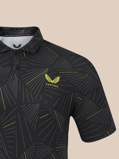 A close-up of a black short-sleeve polo shirt with a geometric yellow and white line pattern, featuring a yellow winged logo and the brand name 'CASTORE' on the left chest.
