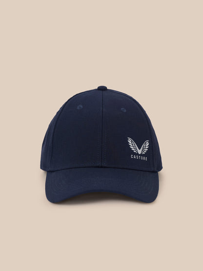 A navy blue baseball cap with a white embroidered winged logo and the word 'CASTORE' on the front, set against a solid beige background.