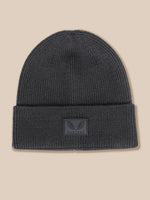 A dark gray ribbed knit beanie hat with a folded cuff, featuring a small rectangular embossed patch on the front with a winged logo and the brand name CASTORE.
