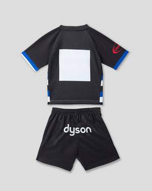 A two-piece kids' athletic set consisting of a black short-sleeve jersey with blue and white sleeve and side accents, and matching black shorts with 'dyson' printed in white on the front, shown on a light gray background.