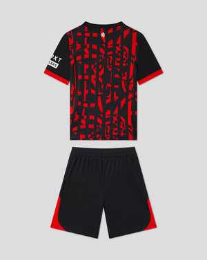 A kids' soccer kit consisting of a short-sleeve jersey and matching shorts. The jersey is black with a bold red abstract geometric pattern across the front, red sleeve cuffs, and a white logo on the right sleeve.