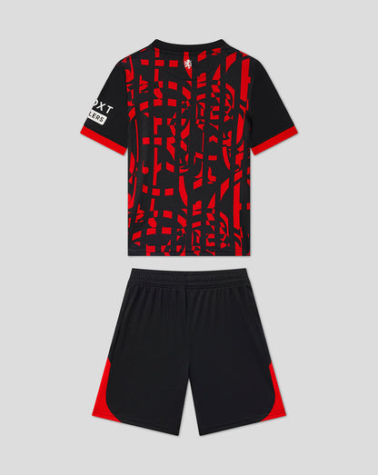 A kids' soccer kit consisting of a short-sleeve jersey and matching shorts. The jersey is black with a bold red abstract geometric pattern across the front, red sleeve cuffs, and a white logo on the right sleeve.