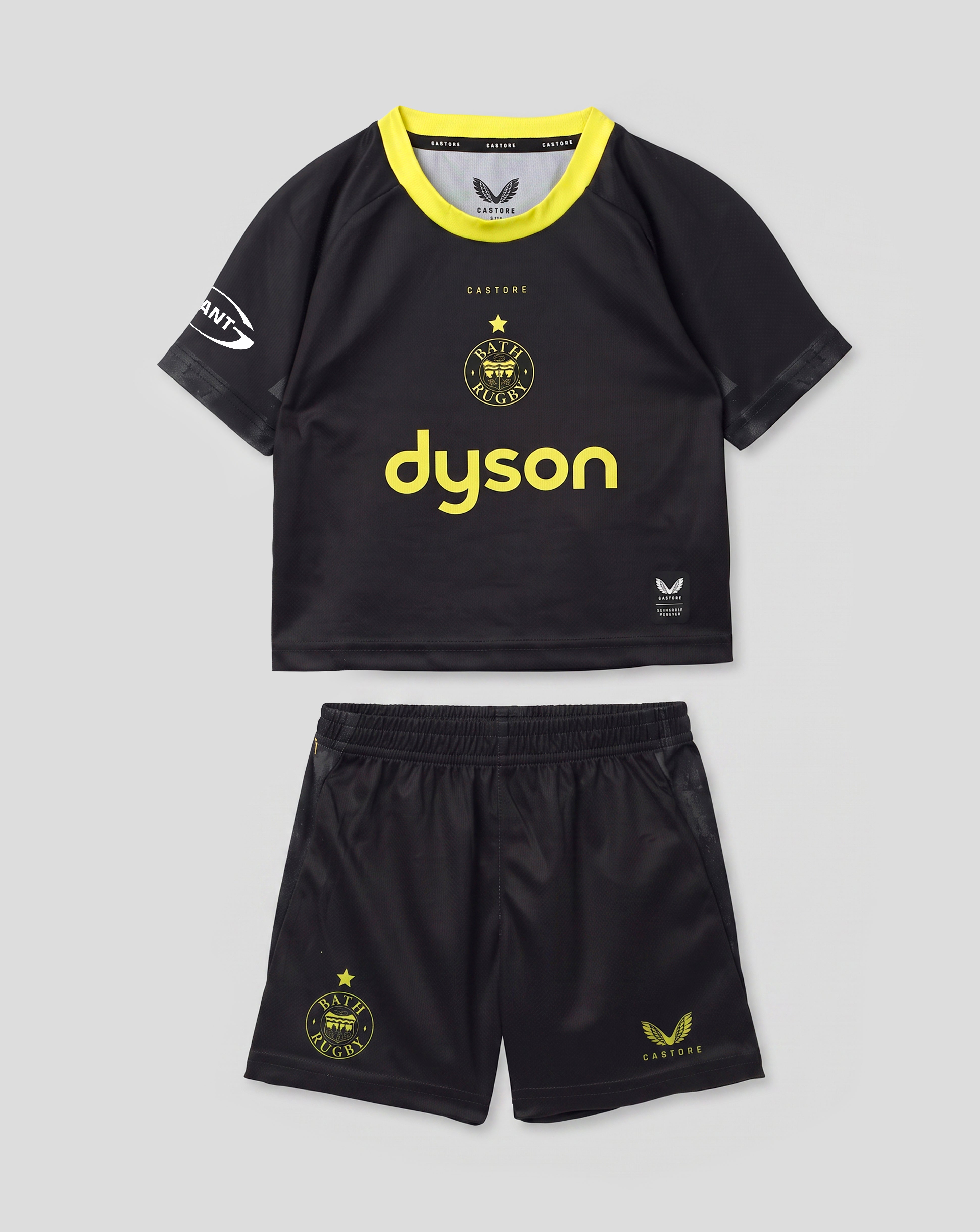 A toddler soccer kit consisting of a black short-sleeve jersey with a bright yellow collar and 'dyson' printed in yellow on the front, paired with matching black shorts featuring yellow graphics, shown against a light gray background.