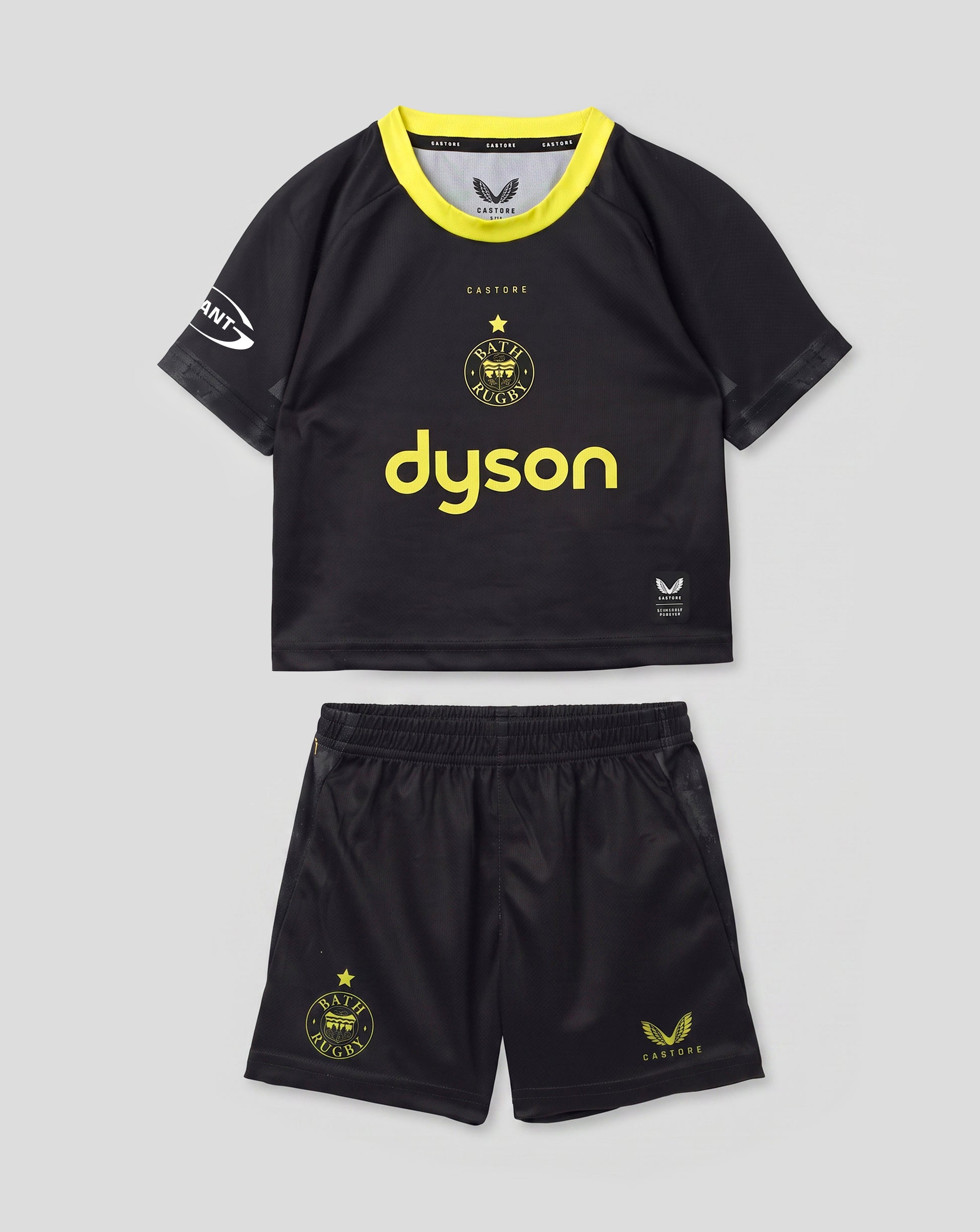 A toddler soccer kit consisting of a black short-sleeve jersey with a bright yellow collar and 'dyson' printed in yellow on the front, paired with matching black shorts featuring yellow graphics, shown against a light gray background.