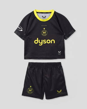 A toddler soccer kit consisting of a black short-sleeve jersey with a bright yellow collar and 'dyson' printed in yellow on the front, paired with matching black shorts featuring yellow graphics, shown against a light gray background.