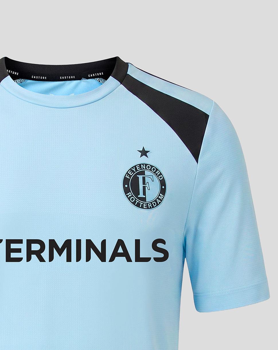 Close-up of the Feyenoord crest and star on a light blue training shirt with black shoulder trim