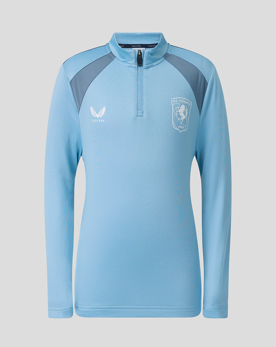 FC Twente junior training mid layer top in light blue with dark shoulder panels and a zip funnel neck.