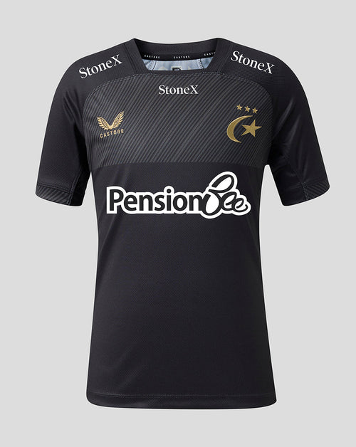 A black short-sleeve sports jersey with a textured dark gray chest panel, featuring the 'Pension Bee' sponsor logo in white across the center, 'StoneX' branding on the shoulders, and a gold winged bird crest with 'Castore' on the right chest, alongside a gold crescent and stars emblem on the left chest, set against a solid light gray background.