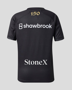 Black short-sleeve athletic jersey shown from the back, featuring a gold '150' print at the collar, a large white 'shawbrook' sponsor logo across the upper back, and a white 'StoneX' sponsor logo near the lower back, set against a solid light gray background.