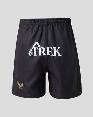 Black athletic shorts with a white Trek logo on the front and a small gold winged logo on the lower left leg, shown against a light gray background.