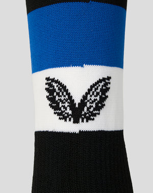 A close-up of a knit crew sock featuring horizontal stripes of black, blue, and white, with a black Castore logo knitted across the white band.