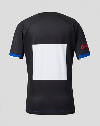 Black short-sleeve athletic jersey shown from the back, featuring a large blank white square on the back, blue trim on the sleeve cuffs, and a red and blue 'GRAM' logo on the right sleeve, set against a solid gray background.