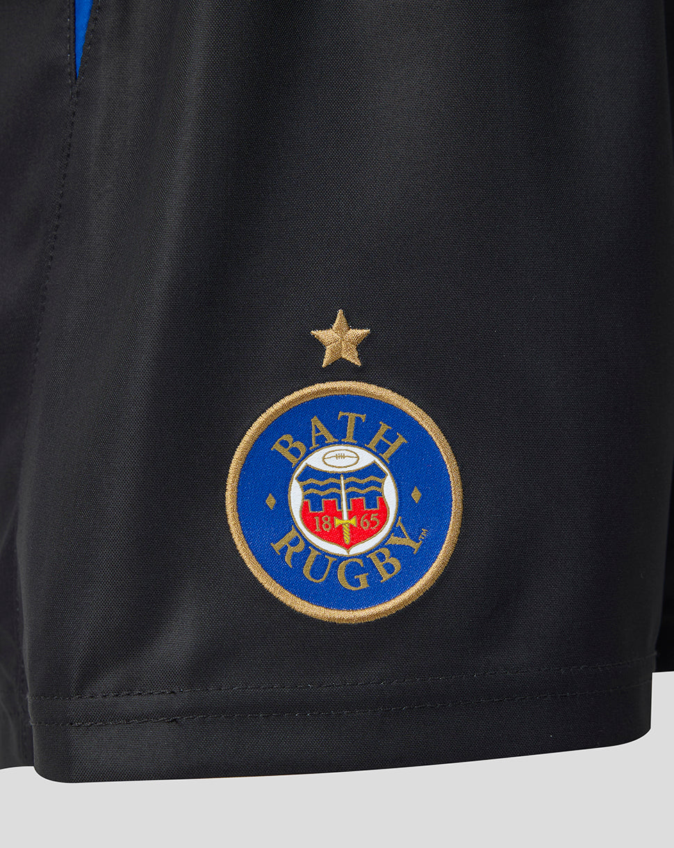 Close-up of a black athletic shorts leg featuring the Bath Rugby club crest embroidered in blue, gold, red, and white, with a gold star above it.
