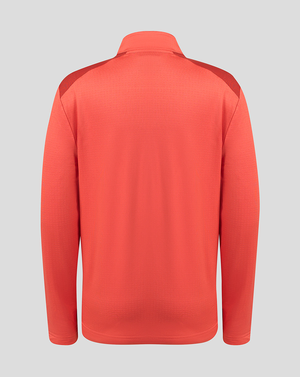A coral red long-sleeve athletic pullover shown from the back, featuring subtle textured knit fabric and darker red shoulder panels, set against a solid light gray background.