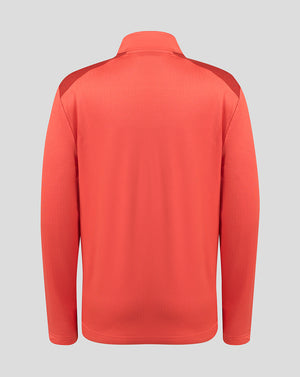 A coral red long-sleeve athletic pullover shown from the back, featuring subtle textured knit fabric and darker red shoulder panels, set against a solid light gray background.