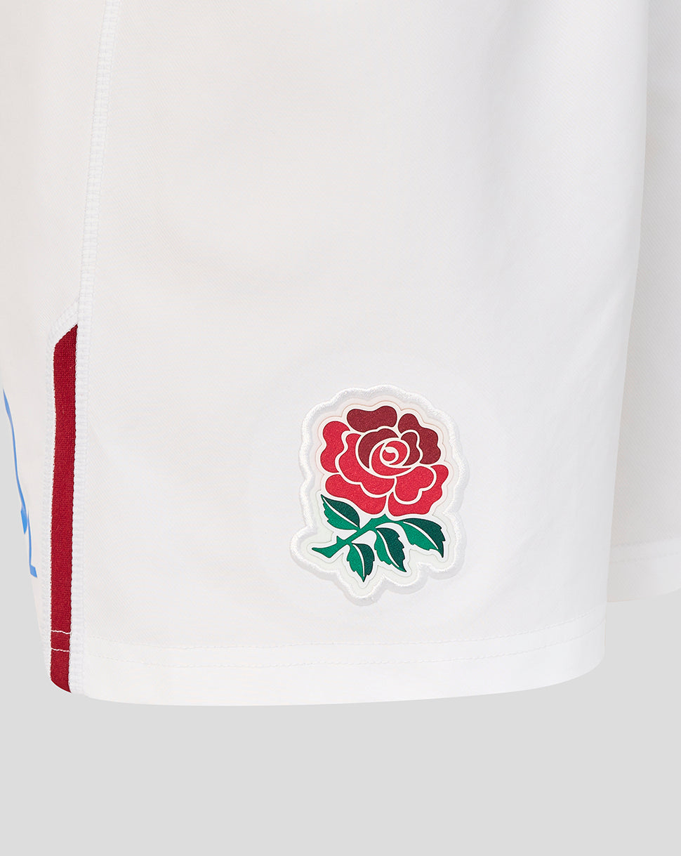 Close-up of a white sports jersey with a red rose emblem on a light gray background